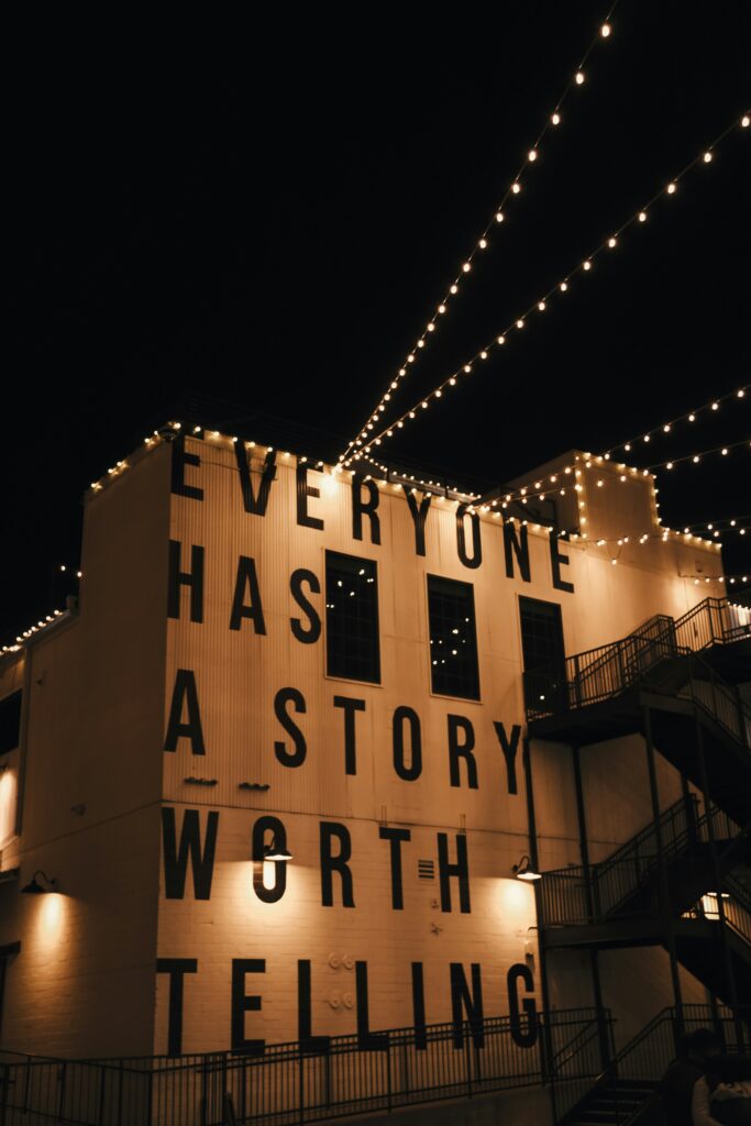 Photo of a building with a large phrase painted on that says, "Everyone has a story worth telling"